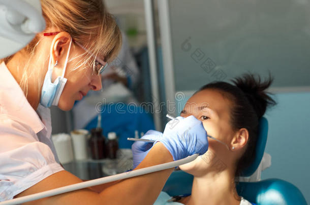 美女牙医在牙科办公室治疗病人的牙齿