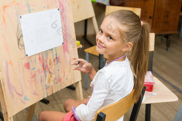女孩在画画课上高兴地看着老师