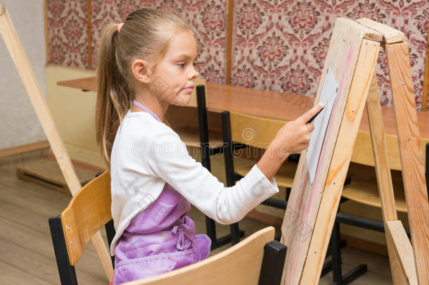 女孩艺术家带着微笑看着绘画课上的图片