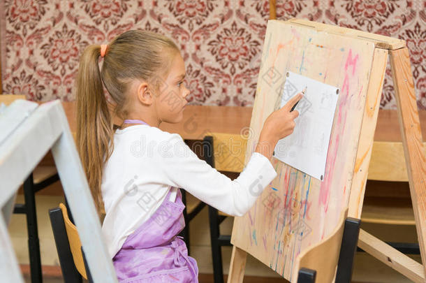 在画画课上，女孩在画架上画画