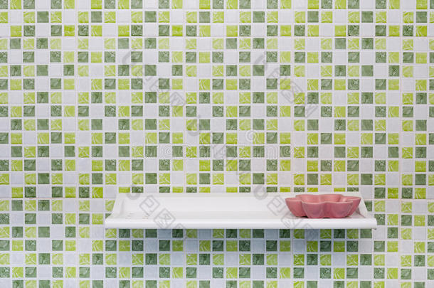 绿色方形瓷砖墙，架子和肥皂盘