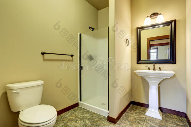 浴室内部有瓷砖地板，水槽，厕所和玻璃淋浴门。
