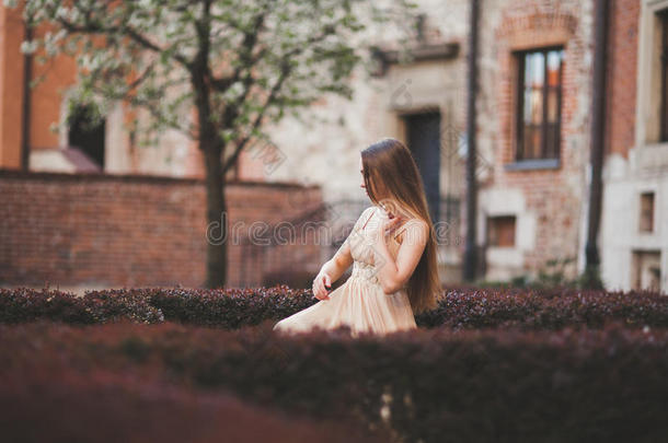 美丽的快乐的女人在公园里，一个温暖的春天，坐在长凳上