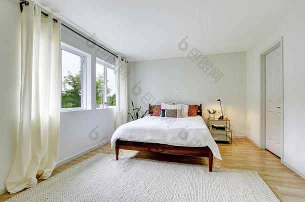 卧室内部轻色调与木床和硬木地板。