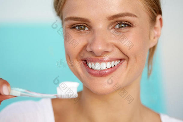 美丽的微笑的女人用刷子<strong>刷牙健康</strong>的白色牙齿