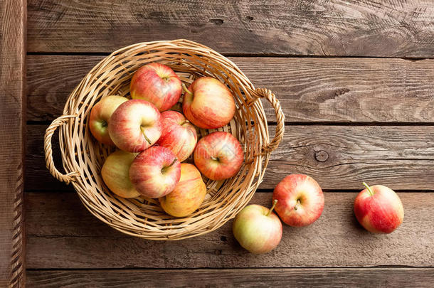 木制桌子上柳条篮子里的新<strong>鲜红</strong>苹果。