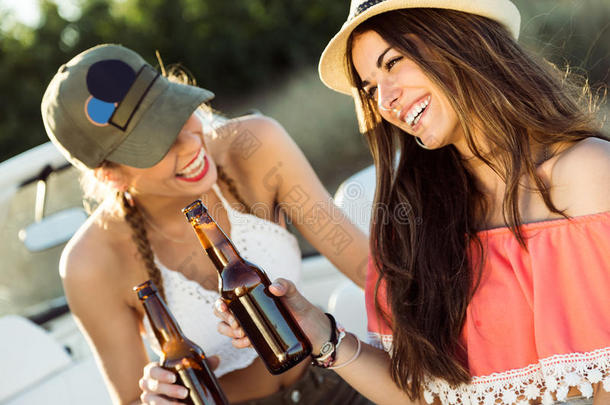 美丽的年轻女人喝啤酒，享受夏日。