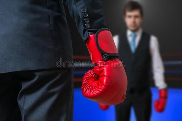 戴着红色拳击手套的商人正在和他的老板拳击