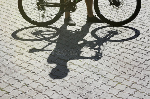 日落时人行道上骑自行车的影子