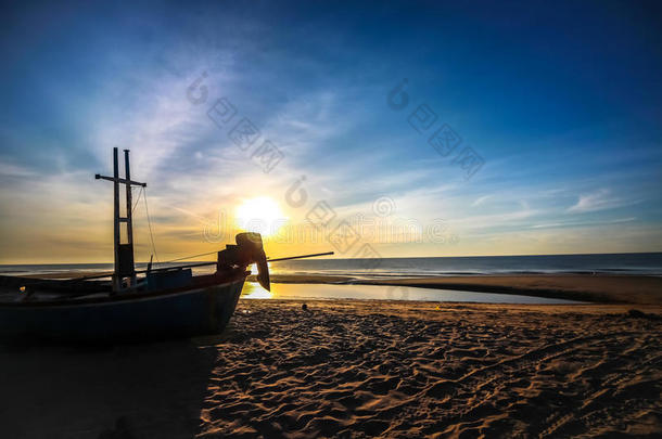 美丽的日落日出背景在海滩上，轮廓船在前景