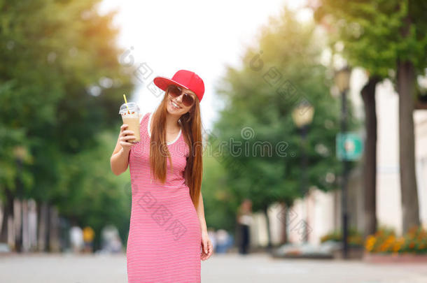 时尚城市肖像时尚时髦的女人奶昔，红色条纹连衣裙，红色帽子和运动鞋，化妆