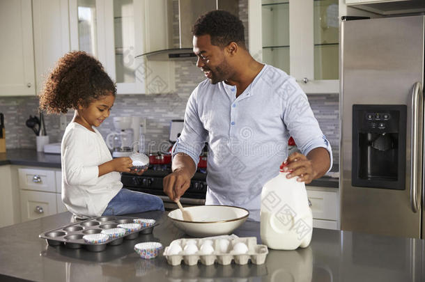 黑人爸爸和小女儿一起在厨房里烤