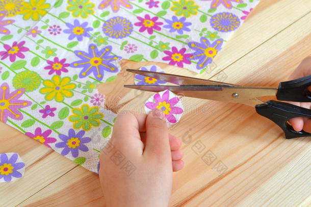 孩子手里拿着剪刀和纸花。 孩子们把花切成碎片，把餐巾纸剪成剪纸