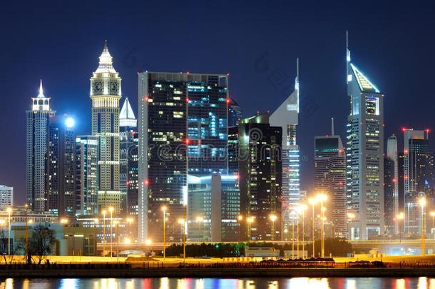 在谢赫扎耶德公路地区惊人的最高摩天大楼在夜间与五颜六色的霓虹灯。 迪拜，阿拉伯联合酋长国。