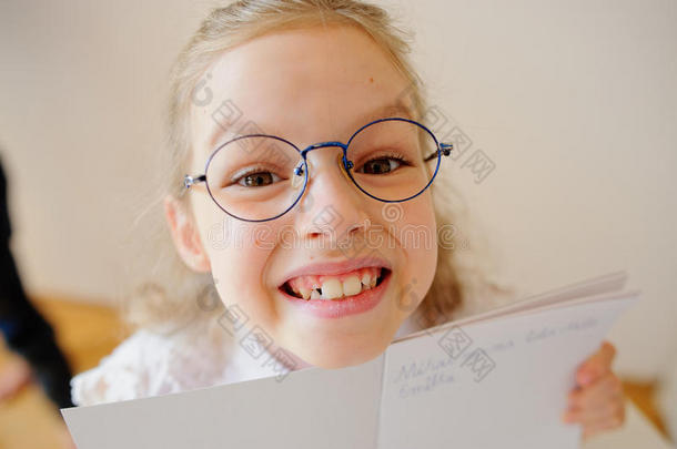 戴眼镜的可爱小女生展示了她的拷贝本。