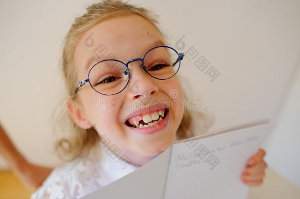戴眼镜的可爱<strong>小女生</strong>展示了她的拷贝本。