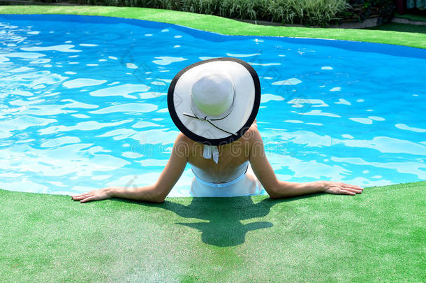 美丽的女人在游泳池边晒太阳。 <strong>暑期</strong>背景。