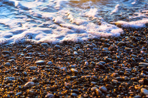 泡沫海浪涌向卵石海岸