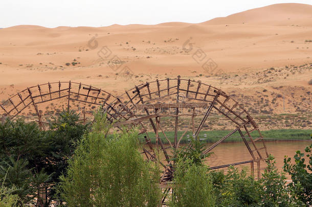 古老的水轮在沙漠和<strong>黄河</strong>的背景下，