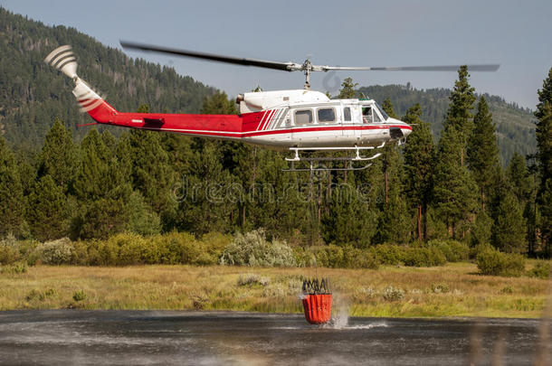 直升机里的消防战士从湖边取水