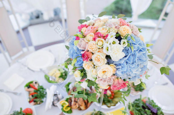 节日桌子上的新鲜花卉构图。 精心组织的活动-为客人准备的宴会桌