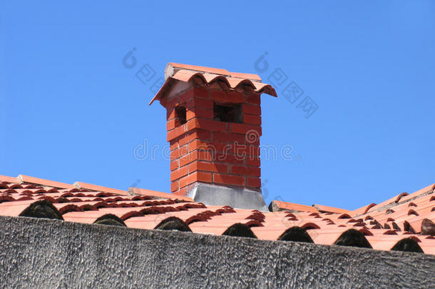 有瓷砖屋顶的房子上的砖砌烟囱