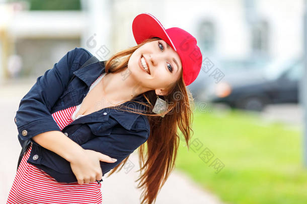 时尚城市肖像时尚时髦的女人，红色条纹连衣裙，红色帽子和运动鞋，化妆，太阳镜，长