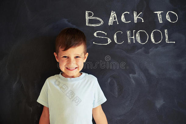 在课堂上靠近黑板的微笑可爱的小学生的特写