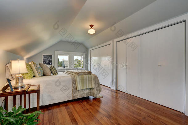 阁楼卧室内部有拱形天花板和硬木地板。