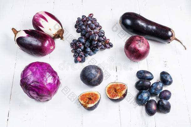 木制背景上新鲜紫色水果和蔬菜的收集
