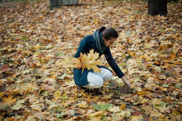秋天散步的女孩穿着大衣在树林里