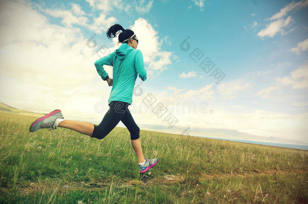 健身女子跑步者在草原上美丽的小径上跑步