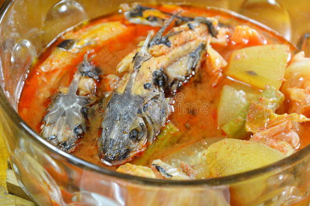 煮鱼与混合蔬菜在辛辣和酸汤在碗上