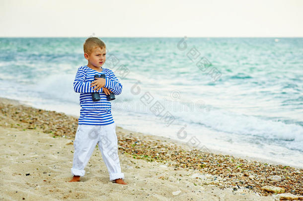 男孩在海滩上摆姿势，穿着海军陆战队的风格