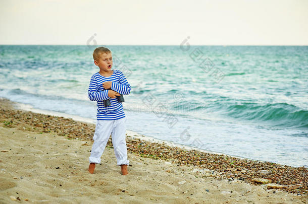 男孩在海滩上摆姿势，穿着海军陆战队的风格