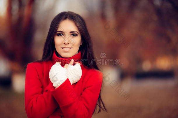 秋天的女人穿着红色的外套和针织的无指手套