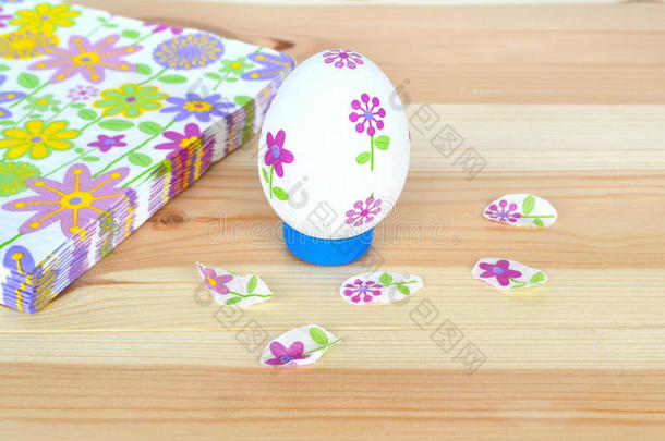 剪纸复活节彩蛋，餐巾纸与花卉图案在一个自然的木制背景