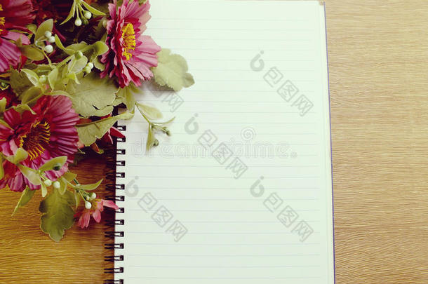 空笔记本页面和人造花与空间复制背景