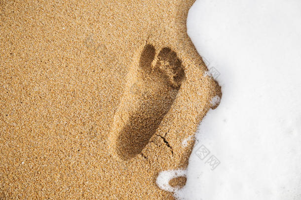 用泡沫在沙滩上留下脚印