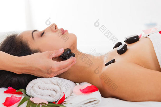 美容师为妇女在健康中心做石头按摩水疗