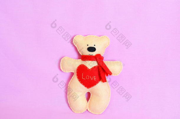 粉红色背景上可爱的米色泰迪熊。 感觉米色的熊带着<strong>红领巾</strong>，心带着爱。 情人节工艺品