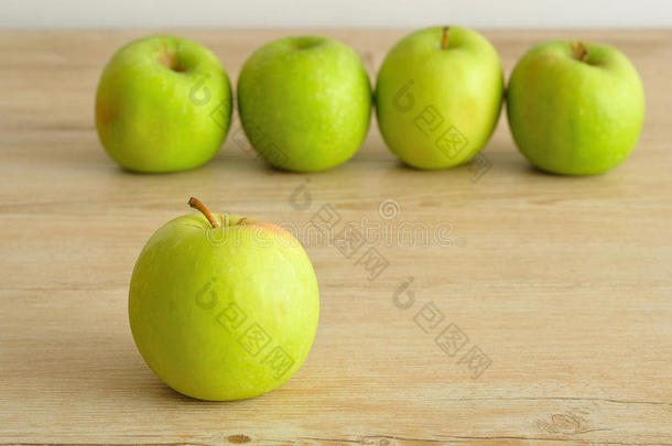 一个绿色的苹果展示在木制背景上