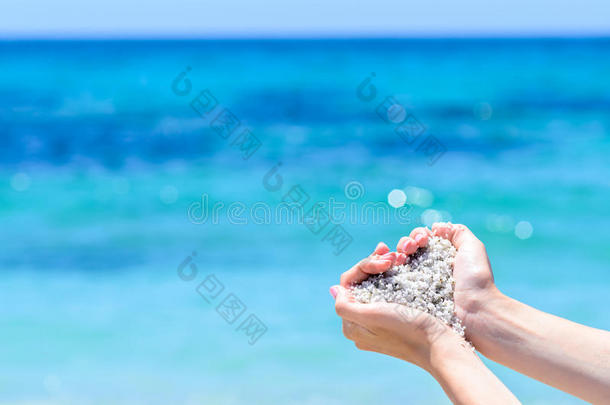 特写手与沙子的形状，在热带绿松石海