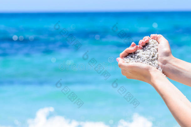 特写手与沙子的形状，在热带绿松石海