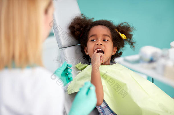 黑人女孩表现出手指疼痛的牙齿