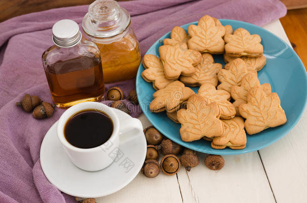 加拿大枫树奶油饼干在蓝色盘子与蜂蜜，枫树糖浆，橡子和白色咖啡