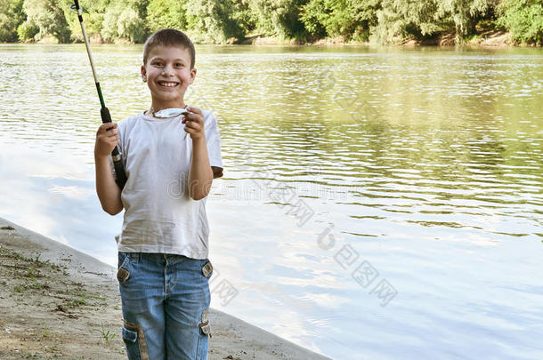 男孩在诱饵上钓鱼，孩子露营和钓鱼，河流和森林，夏季
