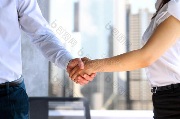 两位同事签订合同后坚定握手的特写形象