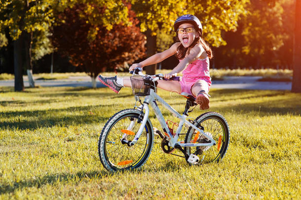 孩子骑自行车。 骑自行车戴头盔的孩子