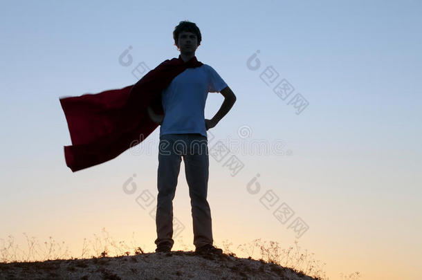 在天空背景上扮演超级英雄的男孩，十几岁的超级英雄